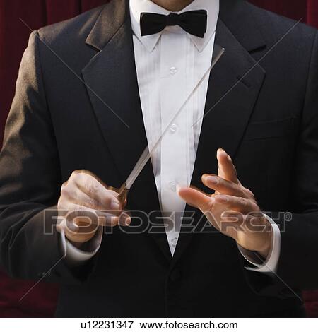 Stock Photo - Male conductor holding baton. Fotosearch