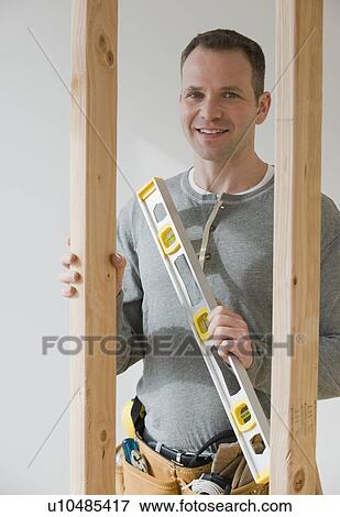 Male construction worker holding level tool View Large Photo Image Stock Photo - Male construction worker holding level tool. Fotosearch