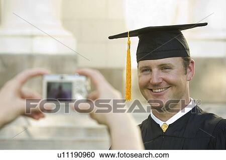 Stock Image - Male graduate having photograph taken. Fotosearch