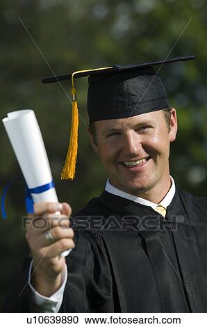 Male graduate holding diploma View Large Photo Image Stock Image - Male graduate holding diploma. Fotosearch