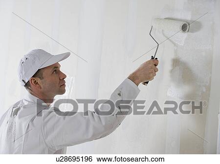 Stock Photograph - Male painter painting with paint roller. Fotosearch