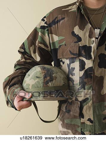 Stock Photo - Male soldier holding helmet. Fotosearch