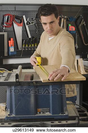 Male woodworker measuring piece of wood View Large Photo Image Stock Photo - Male woodworker measuring piece of wood. Fotosearch