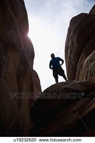 Stock Image - Man atop Red Rock Arches National Park Moab Utah USA. Fotosearch