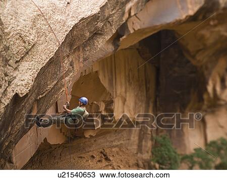 Stock Image - Man canyon rappelling. Fotosearch