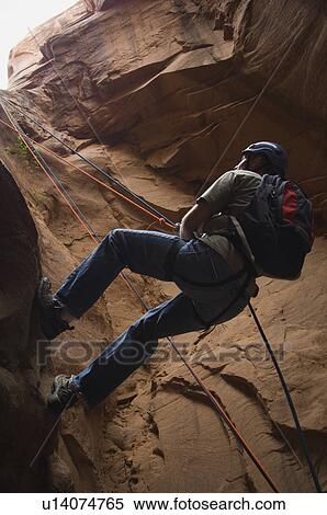 Stock Photography - Man canyon rappelling. Fotosearch