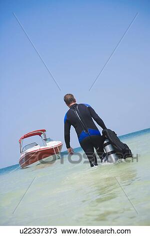 Man carrying scuba gear towards boat, Florida, United States View Large Photo Image Stock Image - Man carrying scuba gear towards boat, Florida, United States. Fotosearch