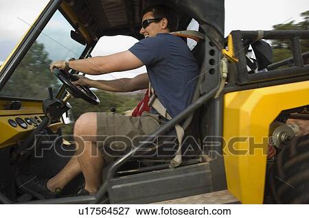 Stock Photo - Man driving off-road vehicle. Fotosearch