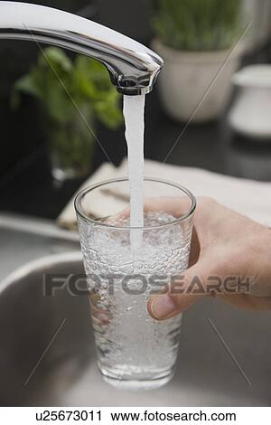 Man filling glass of water at sink View Large Photo Image Stock Image - Man filling glass of water at sink. Fotosearch