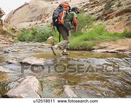 Man hiking through stream View Large Photo Image Stock Image - Man hiking through stream. Fotosearch