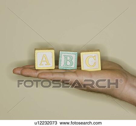 Stock Image - Man holding ABC blocks. Fotosearch