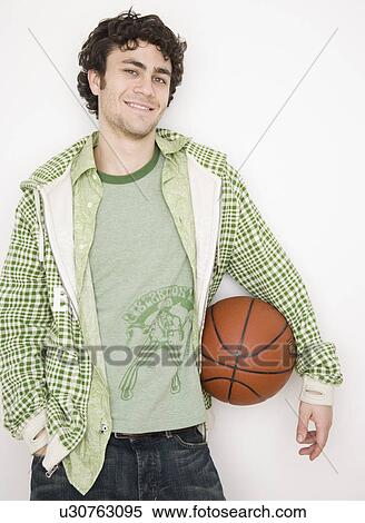 Stock Photography - Man holding basketball. Fotosearch