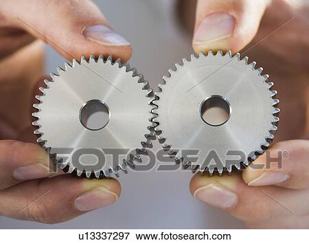 Stock Photo - Man holding cog wheels. Fotosearch