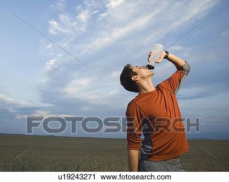 Man in athletic gear drinking water View Large Photo Image Stock Image - Man in athletic gear drinking water. Fotosearch