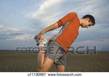 Man in athletic gear stretching View Large Photo Image Stock Photo - Man in athletic gear stretching. Fotosearch