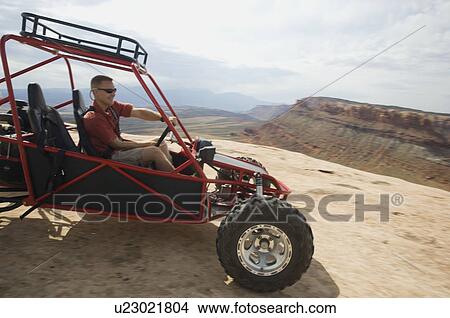 Man in off-road vehicle on rock formation View Large Photo Image Picture - Man in off-road vehicle on rock formation. Fotosearch