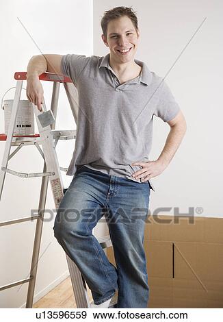 Man leaning on ladder with paint indoors View Large Photo Image Stock Photo - Man leaning on ladder with paint indoors. Fotosearch
