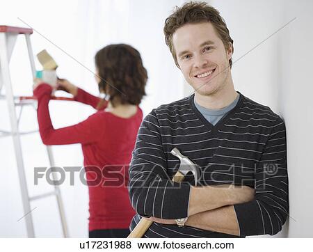 Man leaning on wall holding hammer View Large Photo Image Stock Photo - Man leaning on wall holding hammer. Fotosearch