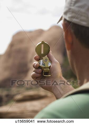 Stock Image - Man looking at compass. Fotosearch