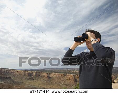 Picture - Man looking through binoculars. Fotosearch
