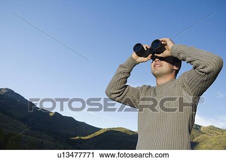 Man looking through binoculars, Utah, United States View Large Photo Image Stock Image - Man looking through binoculars, Utah, United States. Fotosearch