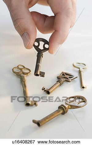 Man picking up old fashioned key View Large Photo Image Stock Photo - Man picking up old fashioned key. Fotosearch