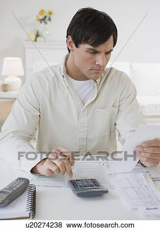 Man preparing taxes View Large Photo Image Stock Photo - Man preparing taxes. Fotosearch