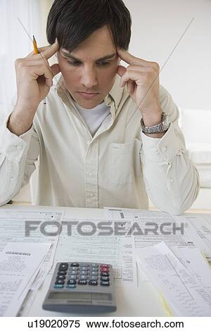 Man preparing taxes View Large Photo Image Stock Photography - Man preparing taxes. Fotosearch