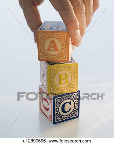 Stock Photograph - Man reaching for ABC blocks. Fotosearch