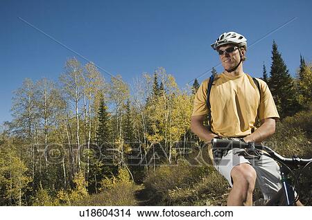 Picture - Man sitting on mountain bike, Utah, United States. Fotosearch
