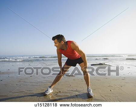 Man stretching at beach View Large Photo Image Stock Photo - Man stretching at beach. Fotosearch