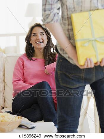 Man surprising girlfriend with gift View Large Photo Image Stock Photo - Man surprising girlfriend with gift. Fotosearch