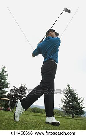Stock Photo - Man swinging golf club. Fotosearch