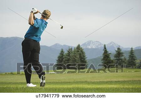 Stock Photo - Man swinging golf club. Fotosearch