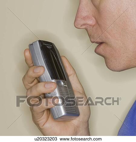 Stock Image - Man talking into voice recorder. Fotosearch
