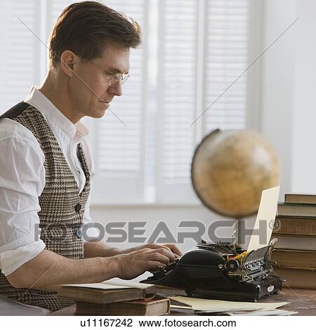 Stock Image - Man typing on antique typewriter. Fotosearch