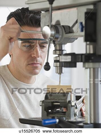 Man using drill press View Large Photo Image Stock Photography - Man using drill press. Fotosearch