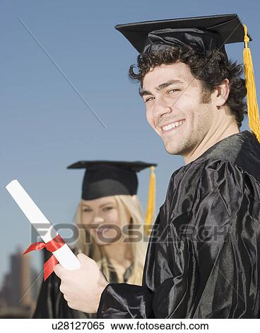 Stock Photography - Man wearing graduation cap and gown with diploma. Fotosearch