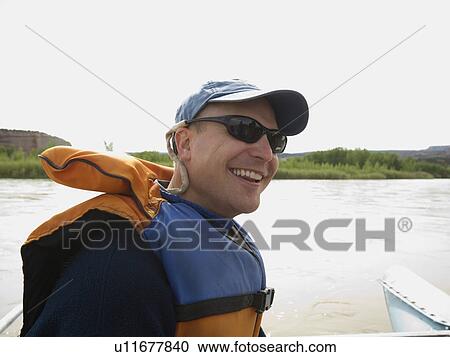 Stock Image - Man wearing lifejacket. Fotosearch