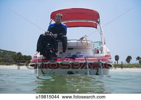 Man with scuba gear on boat, Florida, United States View Large Photo Image Picture - Man with scuba gear on boat, Florida, United States. Fotosearch