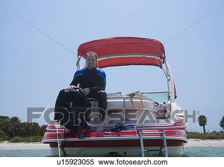 Stock Photography - Man with scuba gear on boat, Florida, United States. Fotosearch