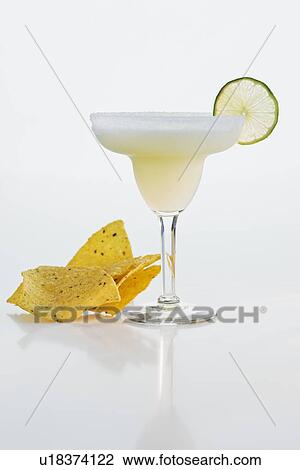 Stock Image - Margarita next to tortilla chips. Fotosearch