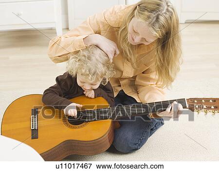 Mother and child playing with guitar View Large Photo Image Stock Photo - Mother and child playing with guitar. Fotosearch