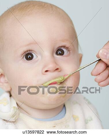 Stock Image - Mother feeding baby. Fotosearch