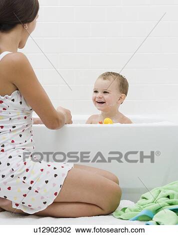 Mother giving baby a bath View Large Photo Image Stock Image - Mother giving baby a bath. Fotosearch