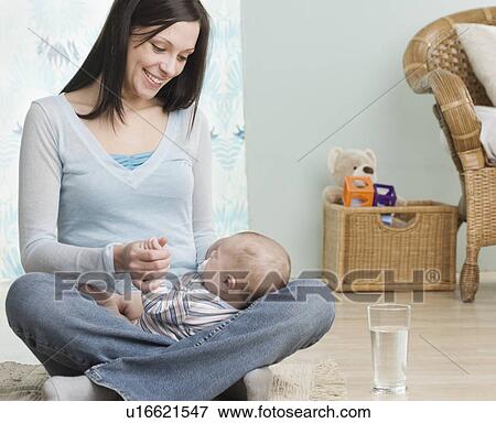Mother holding baby on her lap View Large Photo Image Stock Photo - Mother holding baby on her lap. Fotosearch