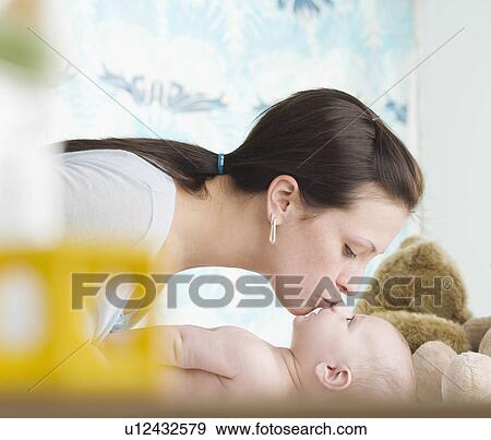 Stock Photo - Mother kissing baby on nose. Fotosearch