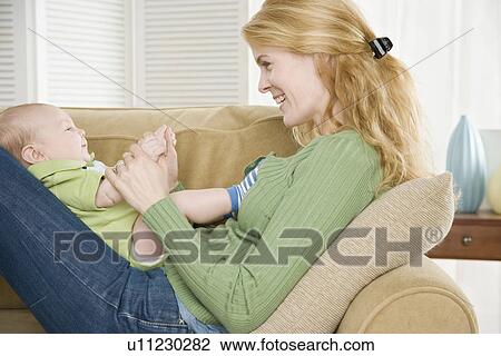 Mother playing with baby on her lap View Large Photo Image Stock Image - Mother playing with baby on her lap. Fotosearch
