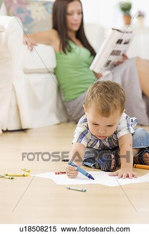 Mother reading while baby colors View Large Photo Image Stock Photography - Mother reading while baby colors. Fotosearch