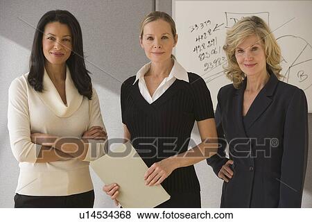 Stock Photo - Multi-ethnic businesswomen in front of whiteboard. Fotosearch